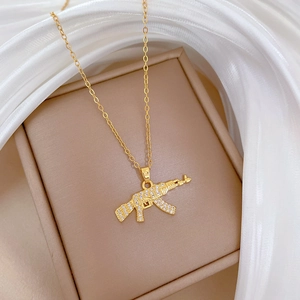 Luxurious gold-plated AK-47 pendant necklace featuring full crystal pavé on a silk background
