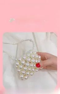 Detail view of mini handmade pearl beaded handbag for girls with round pearl handle