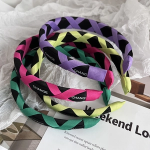 Detail of woven fabric headbands featuring Change letters in multiple candy colors