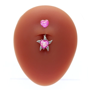Macro detail of a silver belly ring with pink heart gem in star setting on model