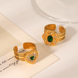 Macro detail of vintage gold hexagram heart rings with green zircon stones