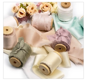 Detailed view of handmade frayed edge chiffon ribbons on wooden spools with floral decor