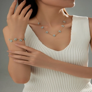 Detail view of light blue flower necklace and bracelet set on a model for a fresh style