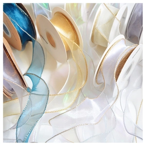 Macro shot of shimmering sheer organza ribbons with metallic gold edges for gift wrapping