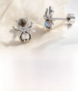 Macro shot of silver spider cartilage stud with zircon stone and screw-back detail