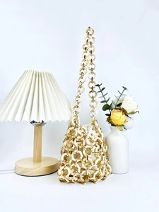 Elegant ivory acrylic bucket bag with hollow geometric links and drawstring inner pouch
