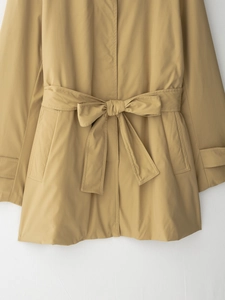 Détail de la ceinture à nœud d'un trench-coat kaki avec des coutures de haute qualité