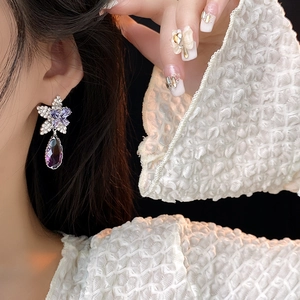 Détail de la boucle d'oreille argentée avec fleur en cristal violet et goutte