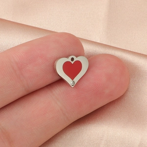 Polished silver heart pendant with red enamel center and small clear crystal detail