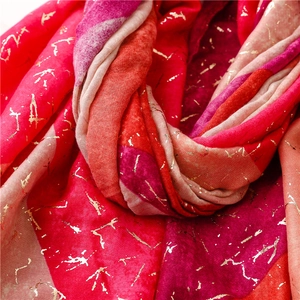 Detail of red gradient cotton linen scarf featuring gold foil prism textures and soft fabric