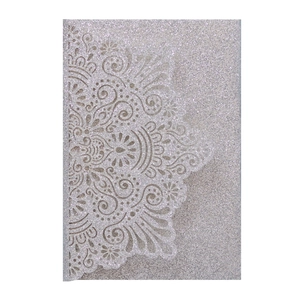 Detail of silver glitter laser-cut invitation sleeve with intricate mandala lace pattern