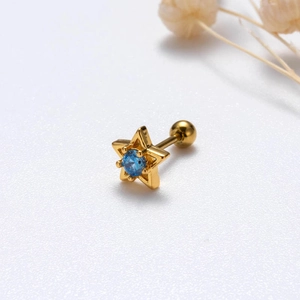 Detailed view of a gold star stud earring with a blue zircon and screw ball back