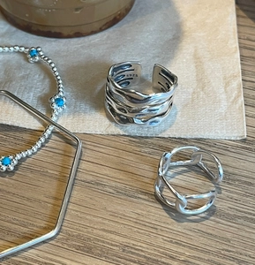 Macro shot of S925 sterling silver multilayer ring and turquoise beaded bracelet
