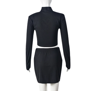 Back view of black ribbed knit two-piece set featuring long sleeve crop top and mini skirt