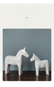 Minimalist white resin horse ornaments set with rustic wood grain texture on dark wood table