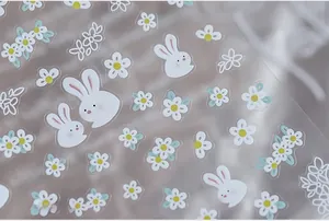 Macro detail of 5D floral rabbit nail stickers with white daisies and bunny patterns