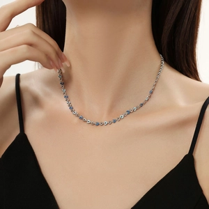 Detail shot of heart enamel charms on a silver titanium steel necklace worn by a model