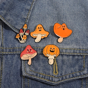 Set di 5 spille in smalto a forma di fungo di Halloween con facce di zucca su giacca