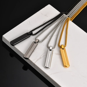 Detailed view of geometric bar pendants in black, grey, silver and gold on marble base