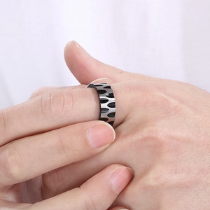Macro shot of silver titanium steel ring with black water ripple textured pattern