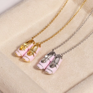 Detailed view of pink enamel ballet slipper pendants in gold and silver finishes