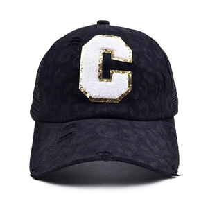 Detail of chenille 'C' patch with gold sequins and leopard print on a vintage mesh cap