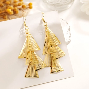 Détail des boucles d'oreilles pendantes à triangles évidés dorés sur carte de présentation