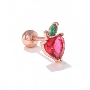 Detailed macro view of strawberry cartilage stud with red zircon and rose gold screw ball