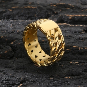 Golden cuban link chain ring with rectangular plaque on black rock from 45-degree angle