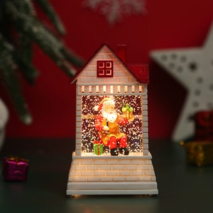 Detail of a white European style Santa cottage lamp with red roof and glowing warm light