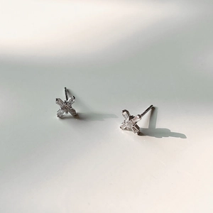 Macro shot of silver X-shaped cross earrings with S925 hallmark and cubic zirconia stones