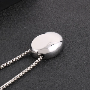 Macro shot of polished silver stainless steel oval pendant on a classic box chain