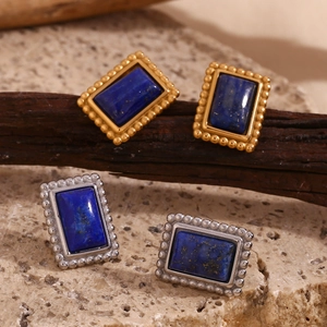 Dettaglio di orecchini vintage con pietra blu e bordo con perline placcato oro