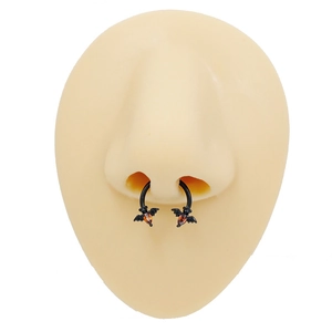 Halloween black bat septum ring with orange gemstone displayed on a nose model