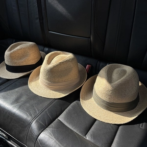 Detailed trio of woven straw Panama hats with black khaki and green bands on leather