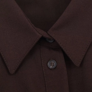 Macro detail of sharp collar and button design on dark brown woven shirt dress