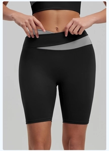 Detail of high-waisted yoga shorts featuring grey and black V-shaped patchwork waistband
