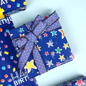 Dark blue birthday wrapping paper with stars and happy birthday text with ribbon