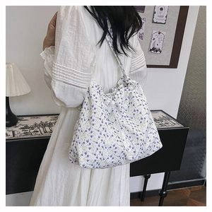 Detailed view of floral shoulder bag with purple and yellow flower prints on model