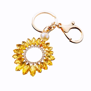 Sparkling sunflower keychain with yellow crystals and center pearl on golden ring