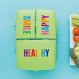 Close-up of green 3-compartment lunch box with Smile Happy Healthy printing