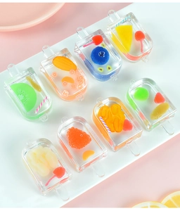 Macro view of mini resin popsicle charms with embedded fruit slices for DIY crafts