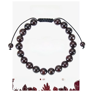 Detailed view of deep red garnet beads on adjustable black woven rope against card paper