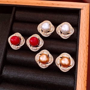 Macro shot of three pairs of vintage pearl earrings with rhinestone borders in a gift box