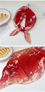 Detail of pleated silk scarf with gradient floral and bird print on white background