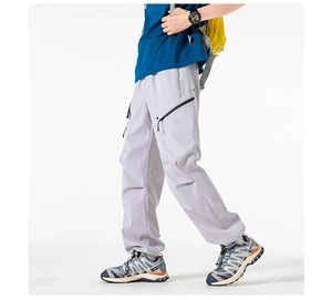 Close-up of light gray cargo pants featuring zipper pockets and adjustable drawstring cuffs