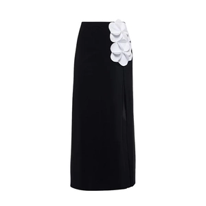 Detail of high-waist black skirt with side slit and white 3D floral decorations