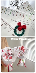 Détail de couronne de Noël au crochet et papier cadeau avec rubans rouges et verts