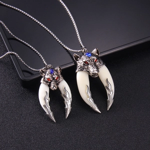 Vintage stainless steel wolf head necklaces with red and blue gem eyes on black surface