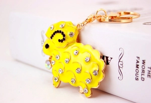 Detail of yellow enamel sheep keychain with black and white rhinestones on golden ring